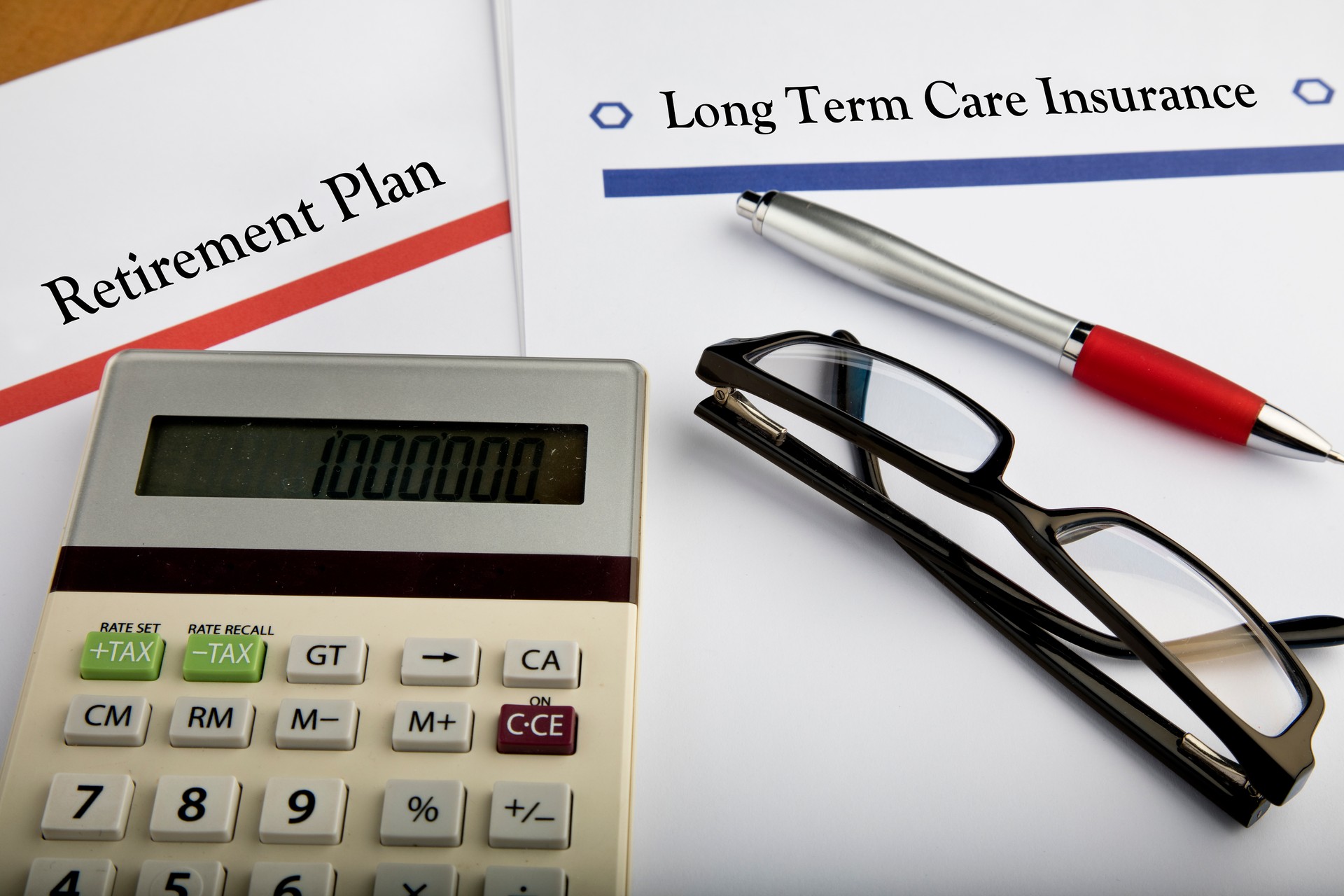 Retirement Plan document with calculator, magnifying glass, pen, and glasses