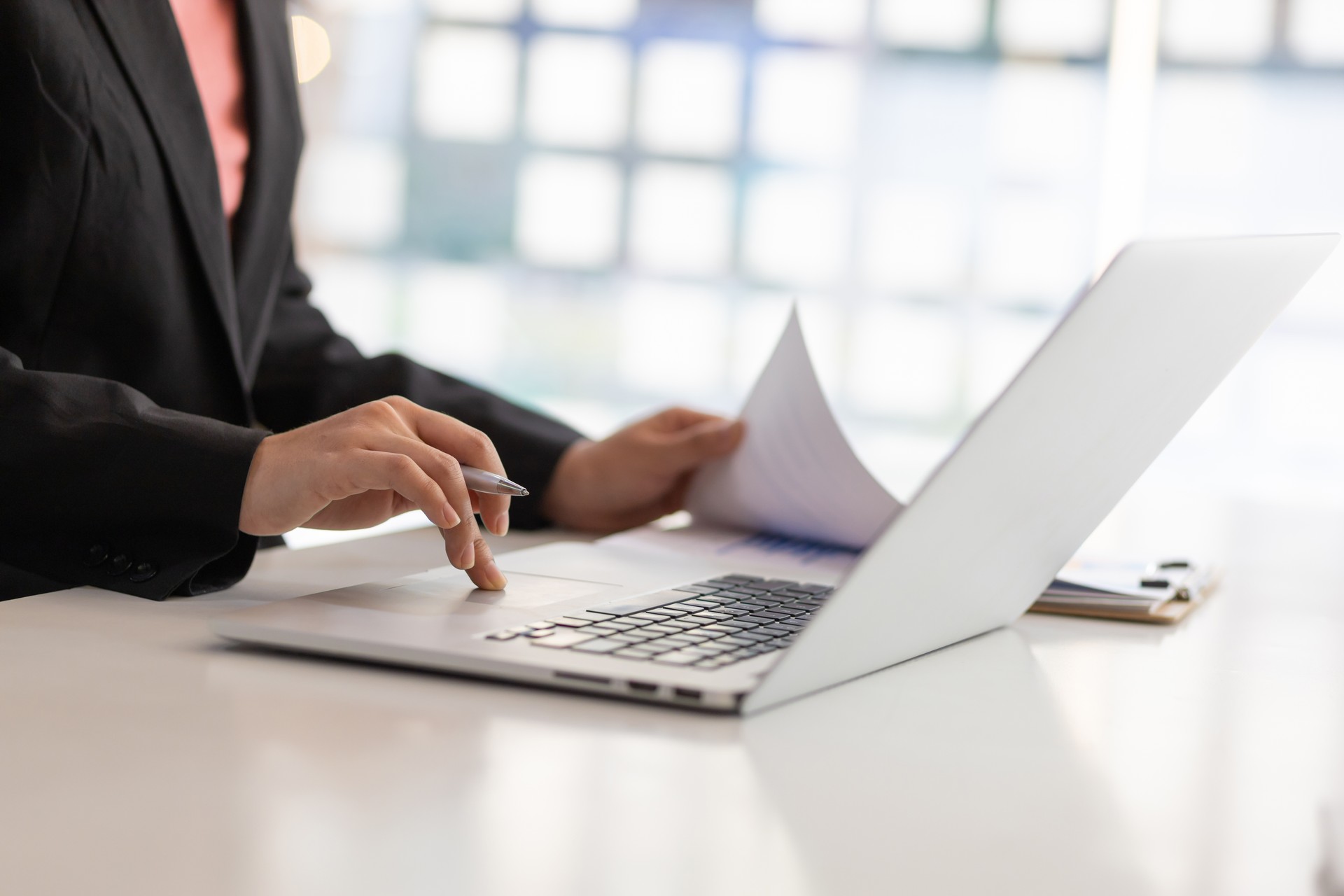 Businesswoman working on laptop and reading financial report chart document. Modern Accounting Concepts and Financial Planning